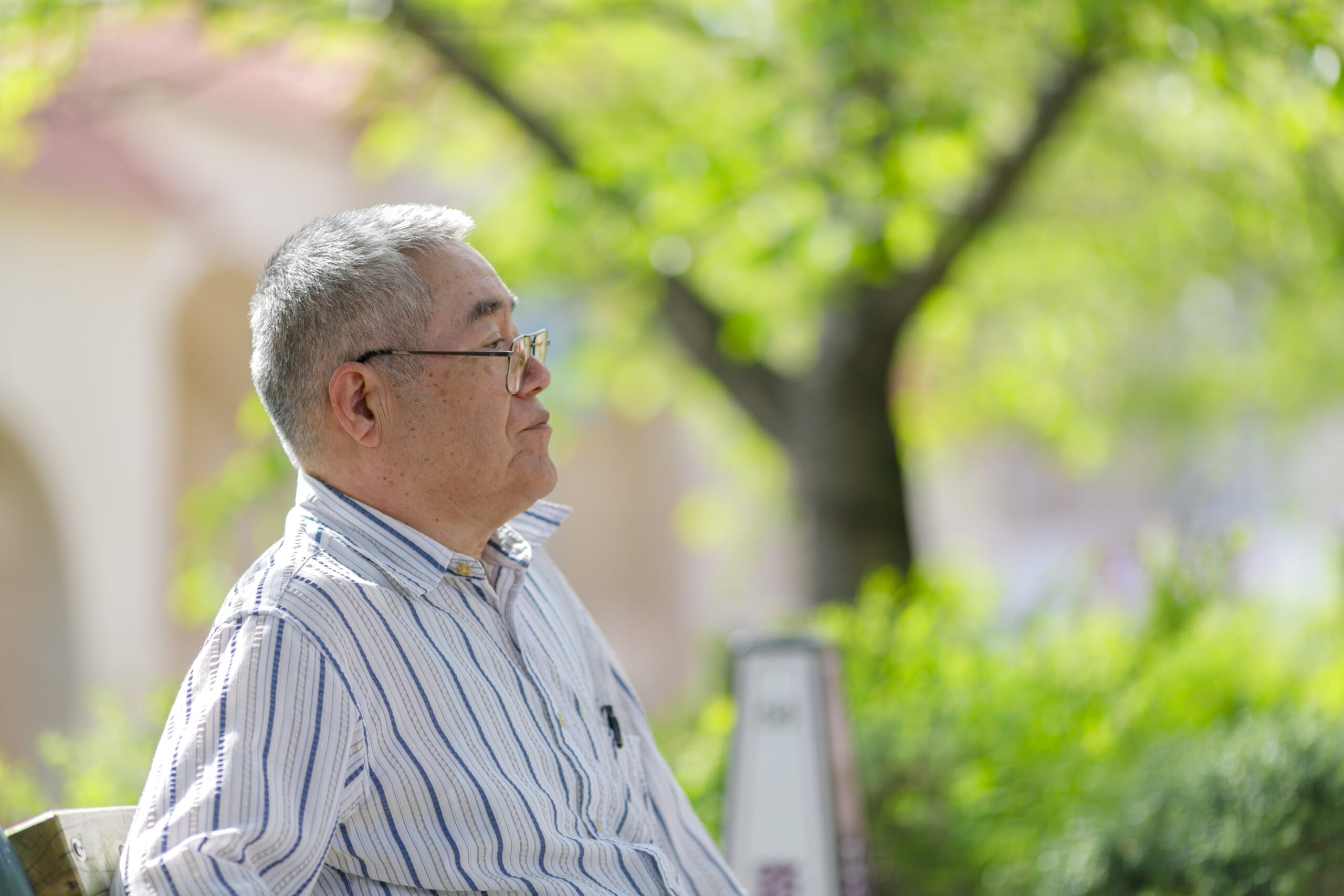 ベンチに座り、ひと息つく喪主の横顔。喪主としての役割を終えた後、自分のケアが後回しにならないように“その先”に目を向ける瞬間