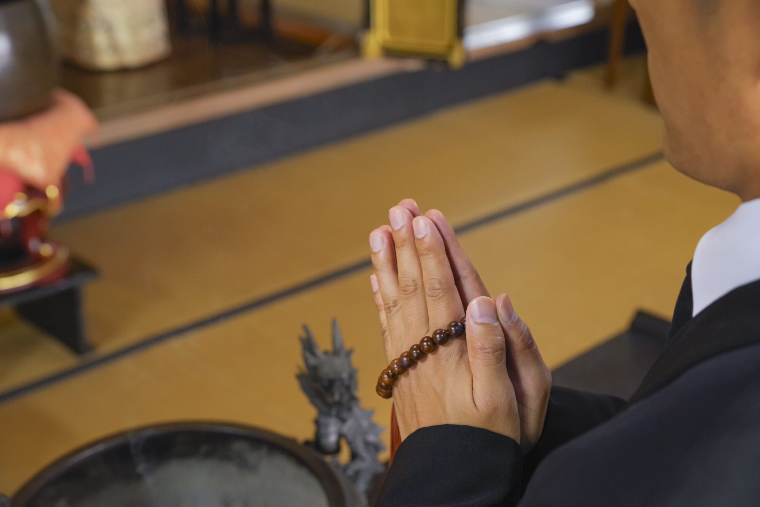 可児市の法事で手を合わせて祈る様子の写真（喪服姿で供養・手を合わせている場面）